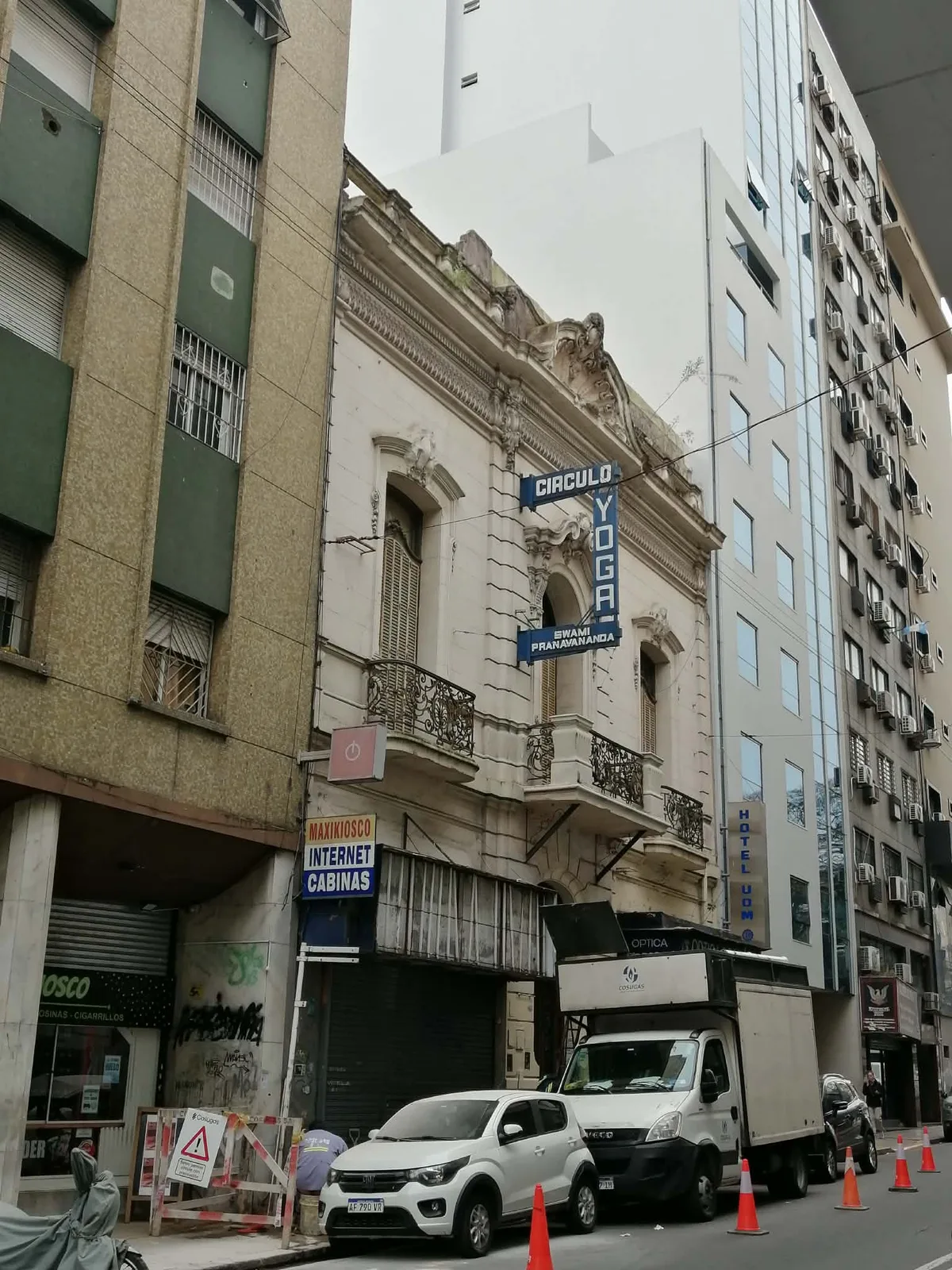 街なかの通り。装飾の多い古い石造りの2階建ての建物が、左右を高層ビルに挟まれて残っている
