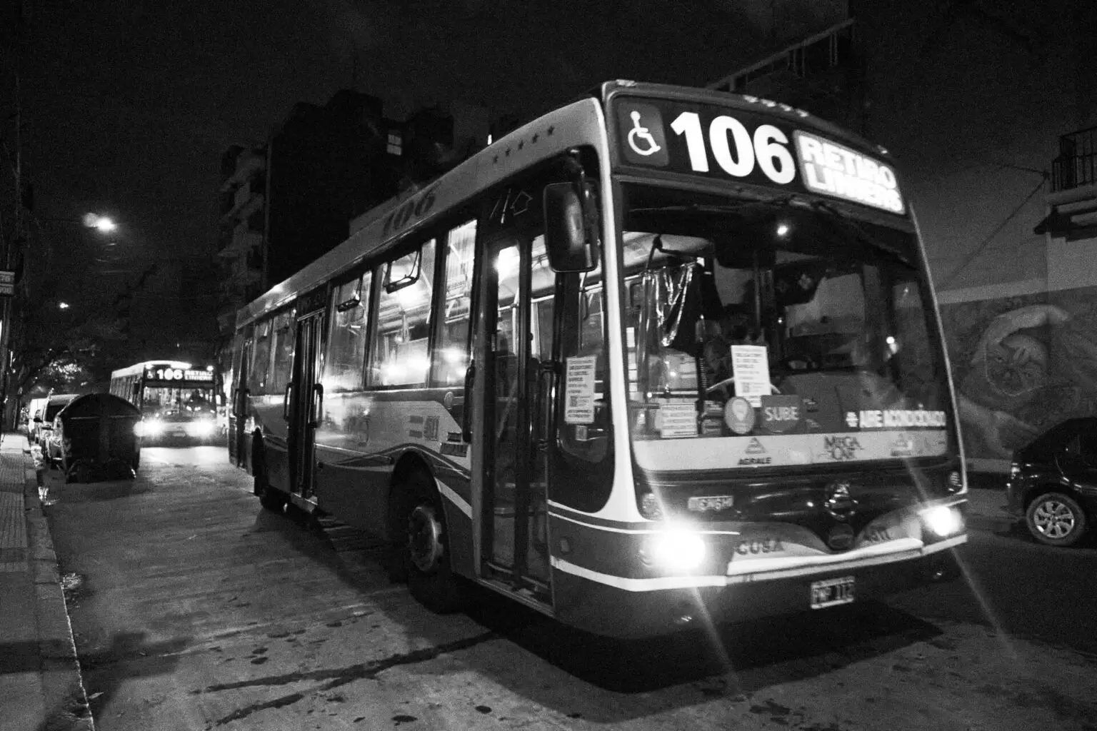 夜の街を走るコレクティーボ。前面の行先表示に RETIRO / LINIERS、窓に SUBE のステッカー