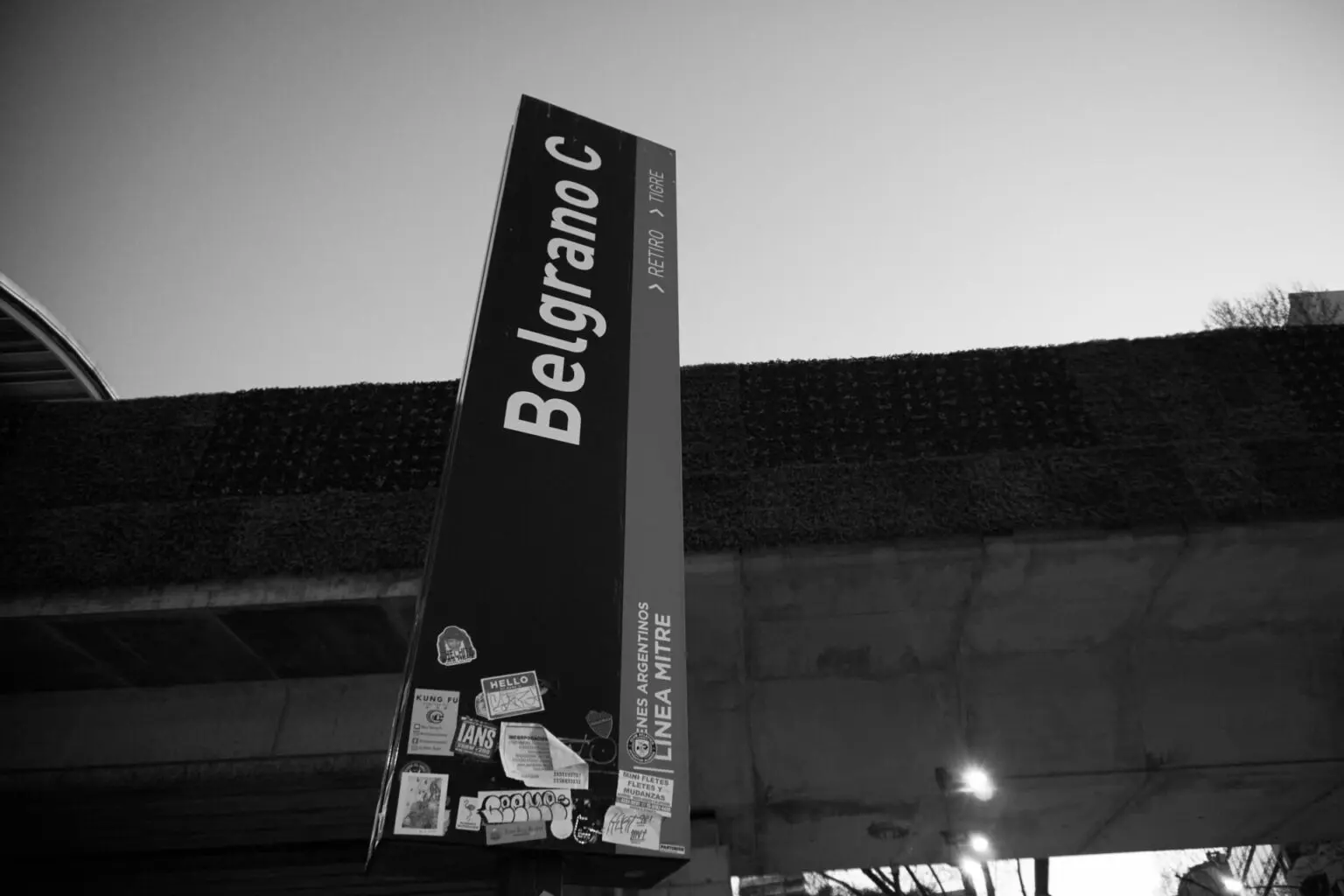 駅の標識。BELGRANO C の駅名と、Línea Mitre、Retiro と Tigre の方向表示