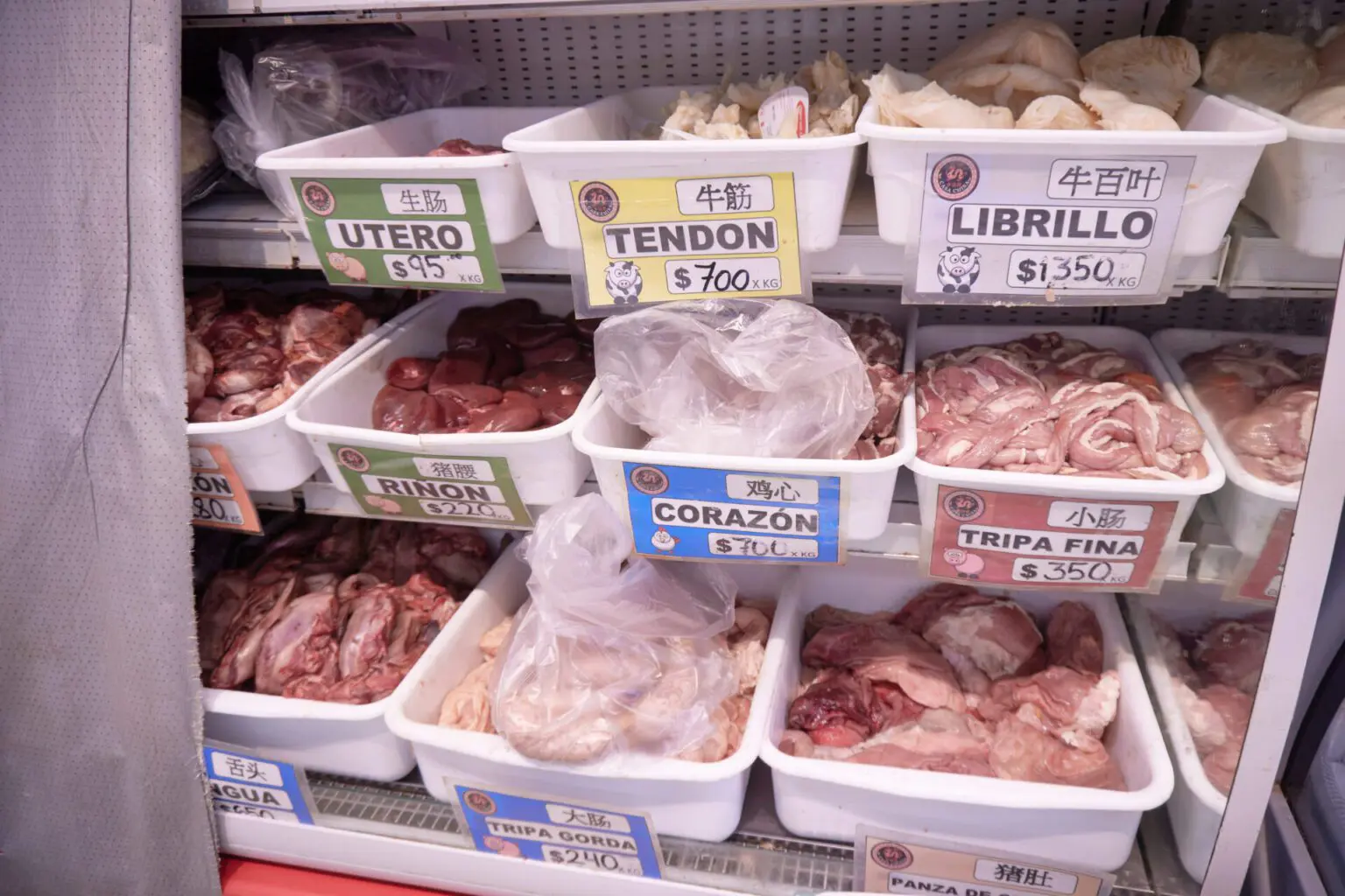精肉店の冷蔵ケース。リニョン、コラソン、トリパ・フィナ、リブリージョと名札が並ぶ