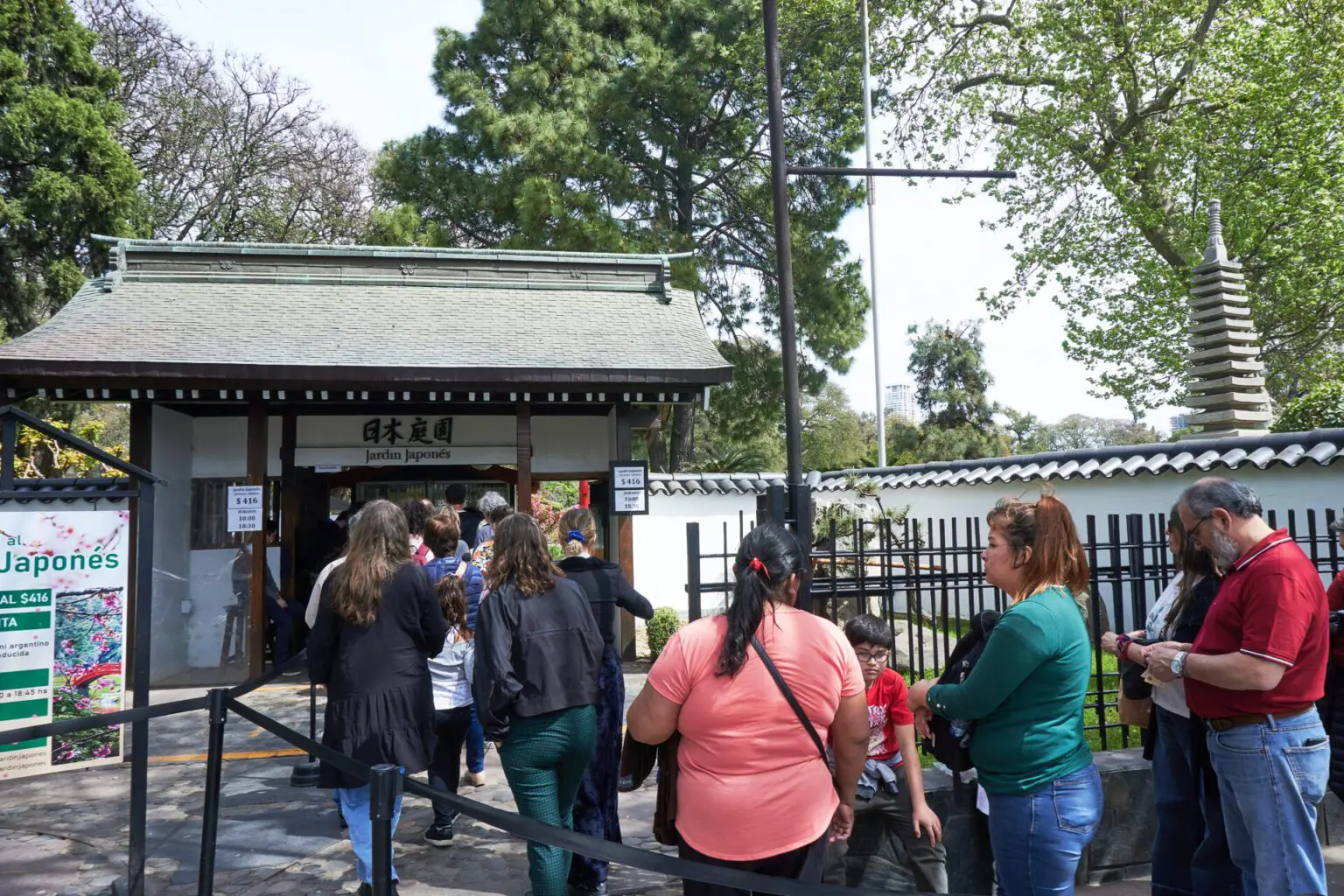 瓦屋根の門の前に並ぶ入場待ちの列。門には日本庭園 Jardín Japonés の額