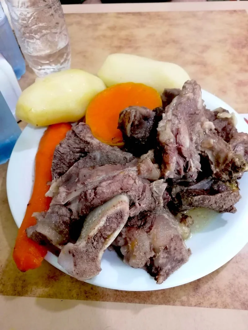 皿に盛られた肉とジャガイモ、ニンジン、カボチャの煮込み